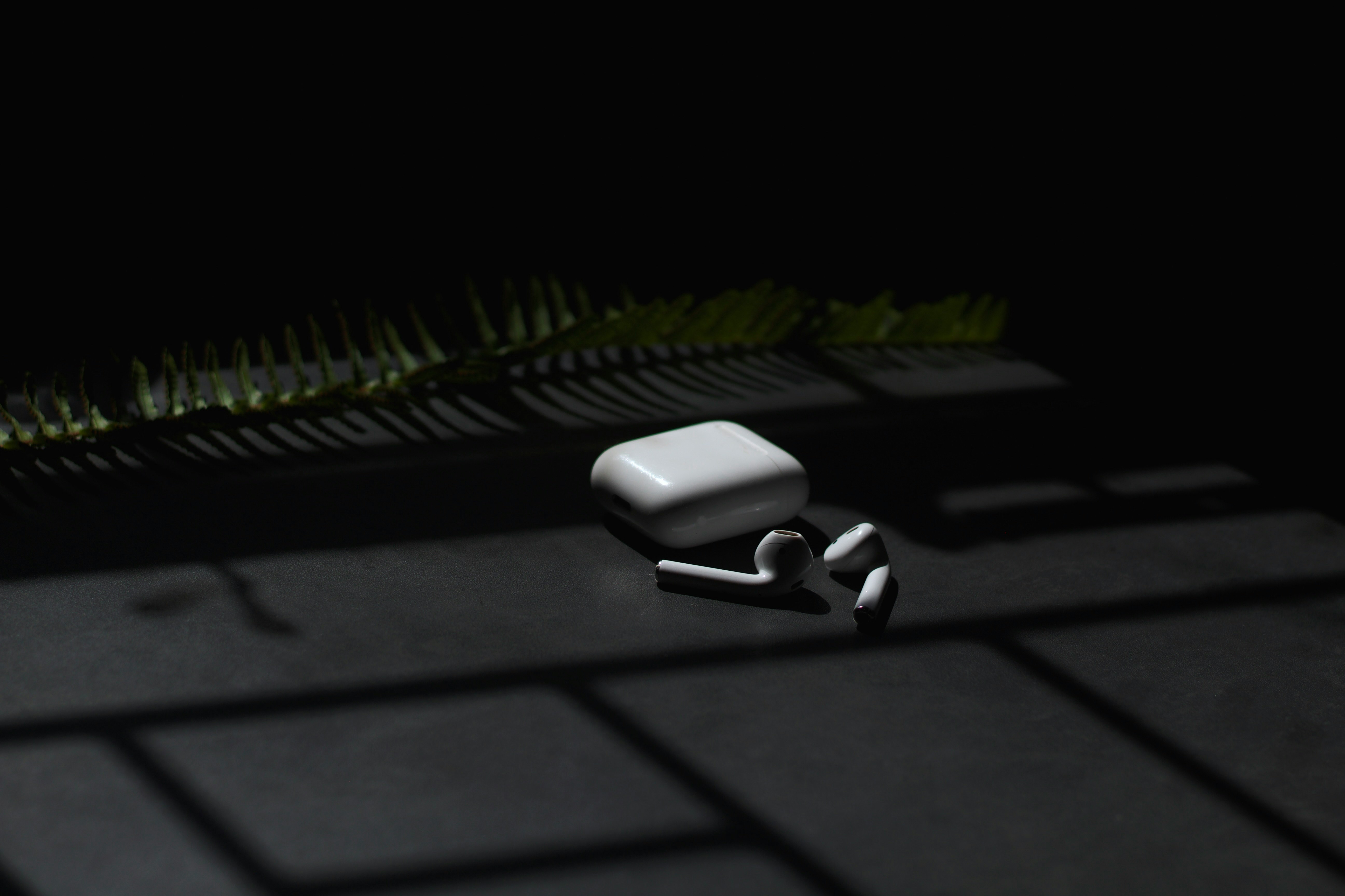 white apple airpods on black surface